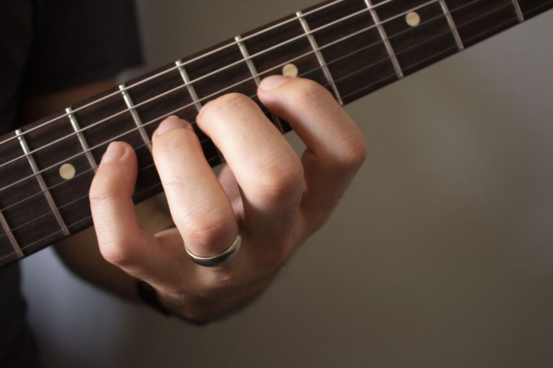 close up of hands playing guitar